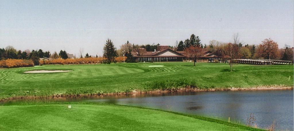 green next to creek with clubhouse in the background